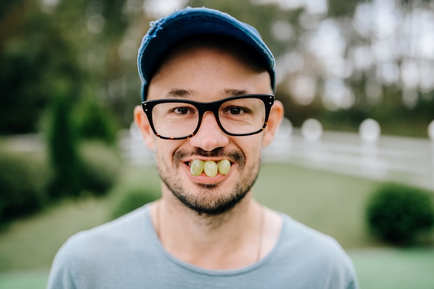 Grappig portret van de vreemde ongebruikelijke glimlachende bebaarde man in glazen op abstracte achtergrond.