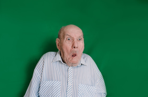Grappig portret van een oudere man op een groene achtergrond