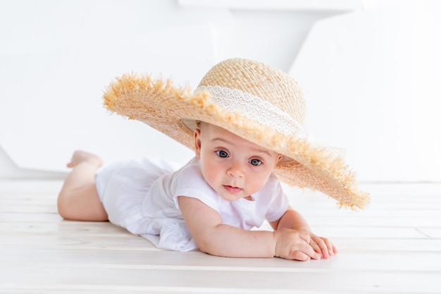 Grappig schattig kind meisje 3-4 jaar oude bedrijf strooien hoed met witte top en denim shorts