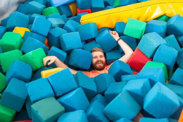 Grappige gelukkige man die plezier heeft op een trampoline binnenshuis