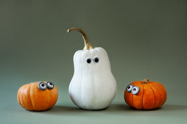 Grappige Halloween-pompoenen met googly ogen op groen