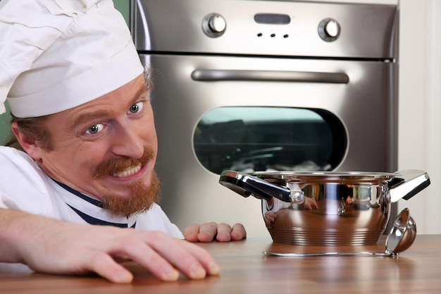 Grappige jonge chef-kok met een pot?