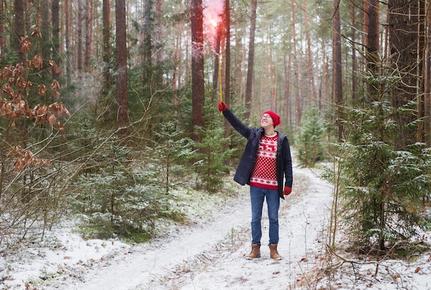 Grappige jonge man in rode hoed in winter woud