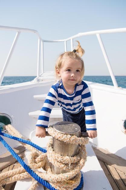 Grappige jongen in gestreept marine shirt kleine matroos op boot zomervakantie jeugd geluk reis ontdekking vervoer gelukkige kleine jongen op jacht reis Zee reis reis concept