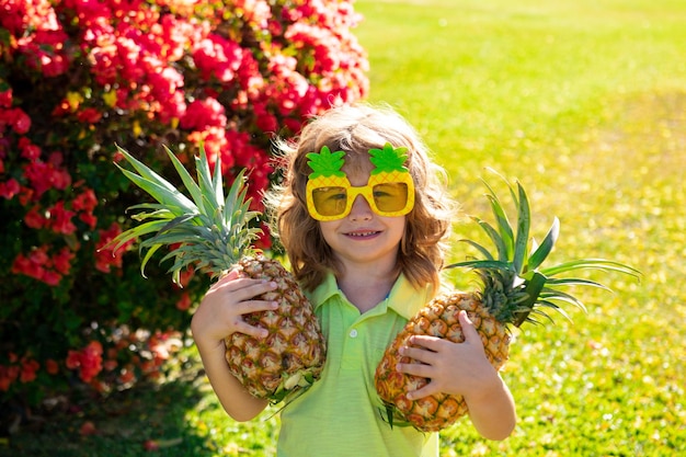 Grappige jongen met ananas, close-up kids gezicht.