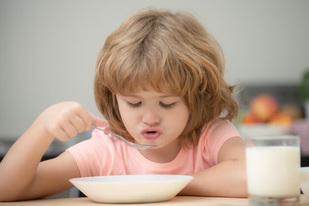 Grappige jongen met bord soep kinderdiner