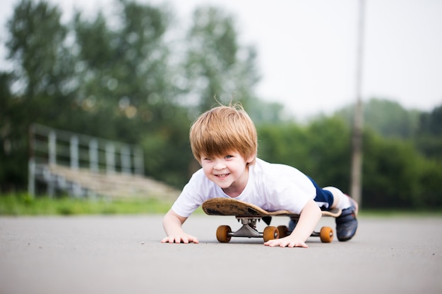 Grappige jongen op een skateboard. Kid rijden skate buiten.