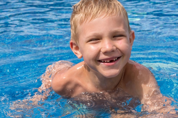 Grappige jongen zwemmen en spelen in een pool