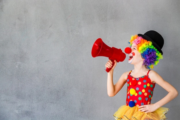 Grappige kinderclown. Kind spreken met megafoon. 1 april Fool's day concept