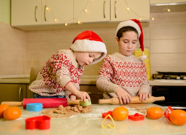 Grappige kinderen bereiden vakantievoedsel voor familie voor. Kerstman koks. Kerstmis