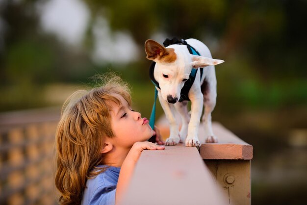 Grappige kinderen gezicht kind omhelst en kust liefdevol zijn hond