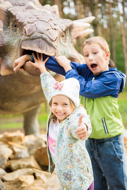 Grappige kinderen spelen in het avontuur dino park. Concept van gelukkige jeugd