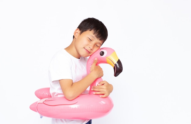 Grappige kleine jongen spelen met roze flamingo reddingsring in, geïsoleerd in het wit