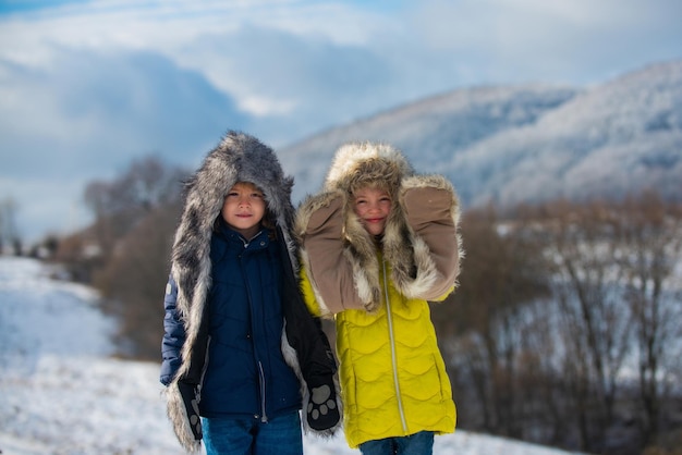 Grappige kleine kinderen in de winter buiten lachende kinderen vrienden in vorst besneeuwde dag buiten twee knappe...