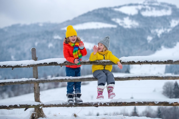 Grappige kleine kinderen in de winter buiten lachende kindervrienden in vorst besneeuwde dag buiten twee knappe