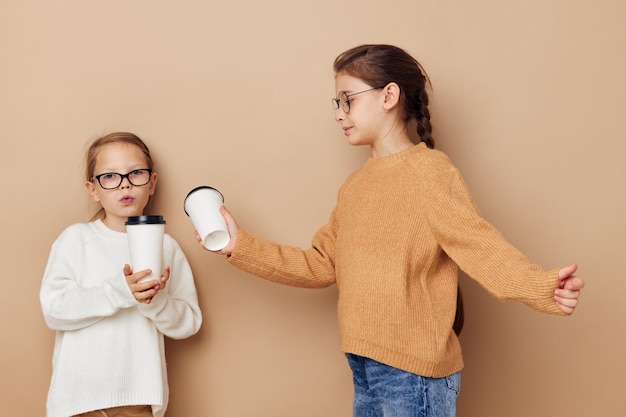 Grappige kleine meisjes met een bril met een drankje