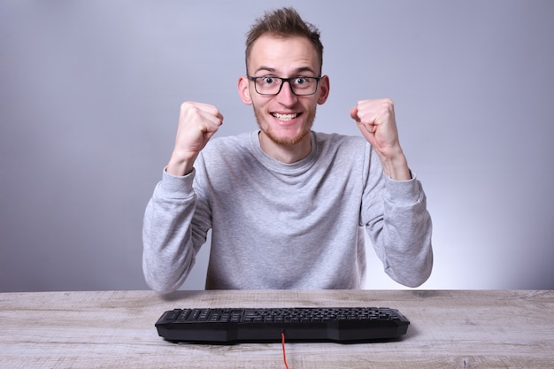 Grappige nerd jonge zakenman, man aan het werk op computer. Typen op het toetsenbord programmeur in glazen voor computer.