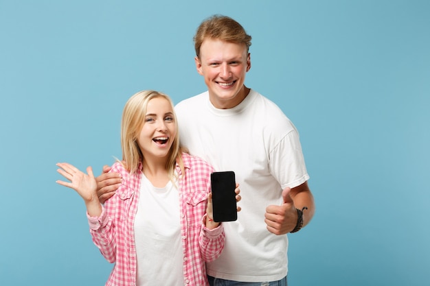 Grappige paar twee vrienden man en vrouw in wit roze t-shirts poseren