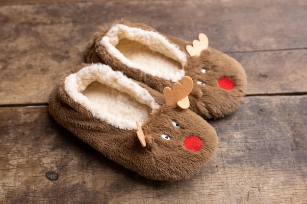 Foto grappige pantoffels in de vorm van een hert op een oude houten achtergrond kerstfoto kopieer ruimte