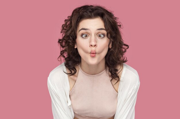 Grappige positieve vrouw die plezier heeft met het maken van vis toont kinderachtig gedrag