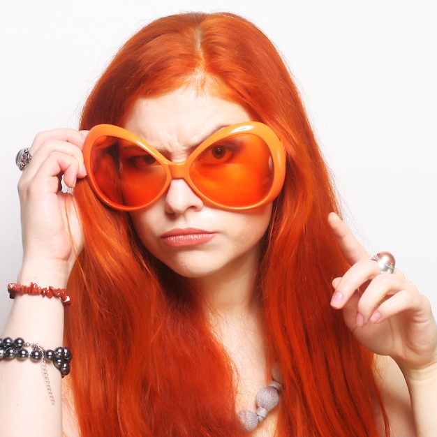 Grappige roodharige vrouw in grote oranje bril
