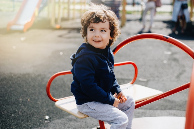 Grappige schattige gelukkig baby spelen op de speelplaats. de emotie van geluk, plezier, vreugde. glimlach van een kind.