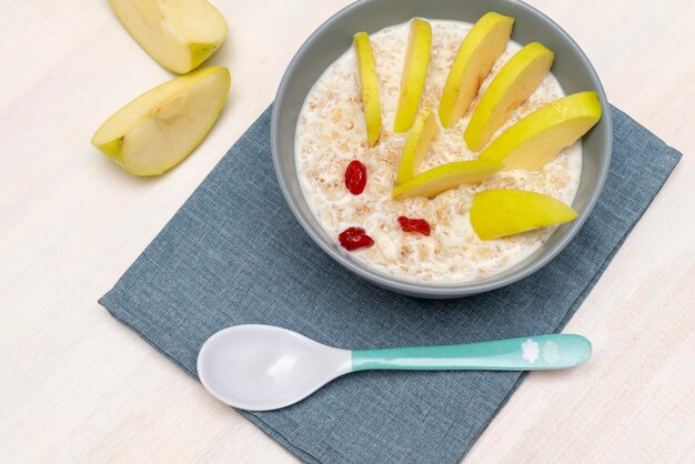 Grappige schattige kinderen kinderontbijt lunch pap zoals egel met appel gedroogde bessen eten