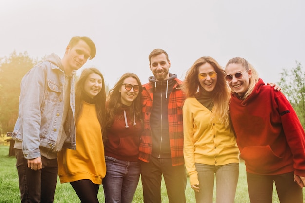 Grappige selfie met vrienden. gezelschap van vrolijke vrienden die selfie maken en glimlachen terwijl ze buiten staan. mensen dragen rode en gele truien. jongeren rusten in de natuur, praten en lachen