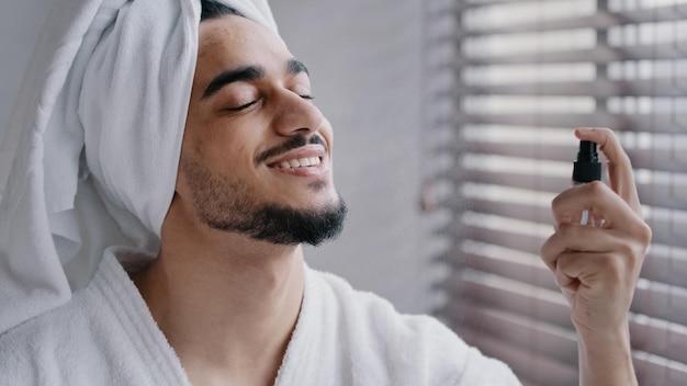 Grappige Spaanse bebaarde Indiase man met witte badhanddoek op hoofd in badkamer schoonheidsprocedures