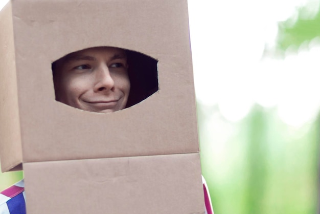 Foto grappige tiener met een doos op zijn hoofd close-up