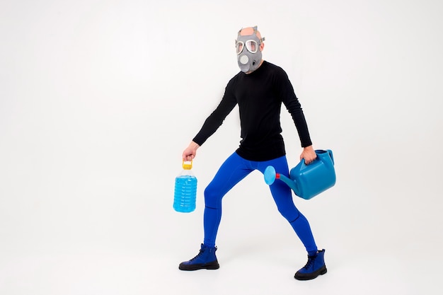 Grappige vreemde man in gasmasker poseren met gieter pot en fles op witte achtergrond