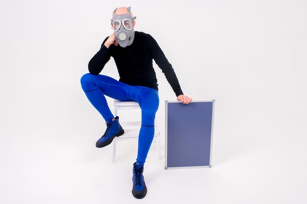 Grappige vreemde man in gasmasker zittend op trapladder met een marker bord op witte achtergrond