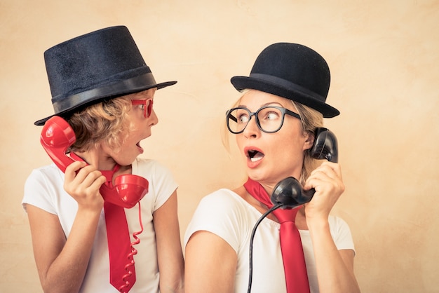 Foto grappige vrouw en kind met valse snor. gelukkige familie die thuis speelt