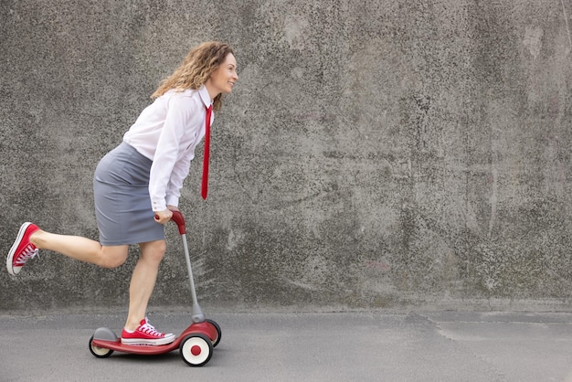 Grappige zakenvrouw scooter buiten rijden