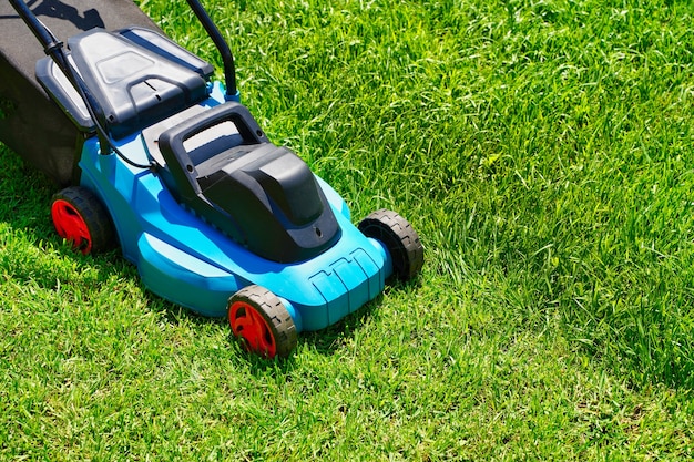 Grasmaaier op een weelderig groen gazon de helft van het gras bijgesneden achtertuin van het huis