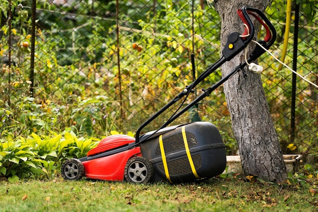 Grasmaaier op groen gras in zonnige dag buiten speciale handmatige machine voor het maaien van gras tuinieren concept