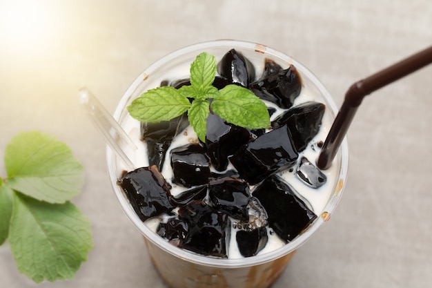 Grass jelly with fresh milk and caramel in plastic cup