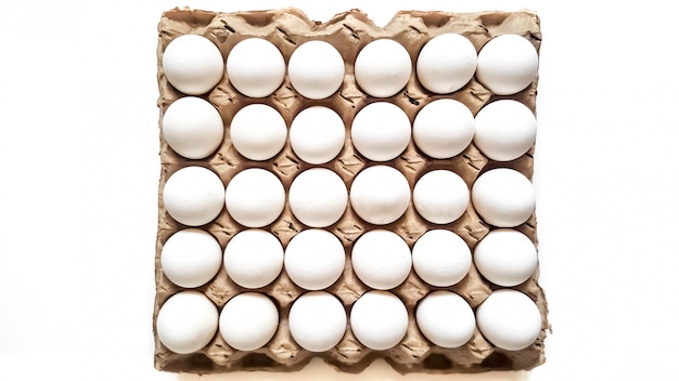 Grate of white eggs of thirty pieces on a white. Top view. Easter Holiday 