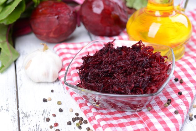 Grated beetroots in bowl on table closeup