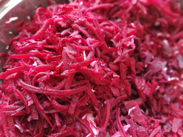 Grated burgundy juicy beets in a saucepan closeup Finely chopped beets for salads soups borscht A vegetarian anticancer diet Raw food diet Soft focus Shallow depth of field