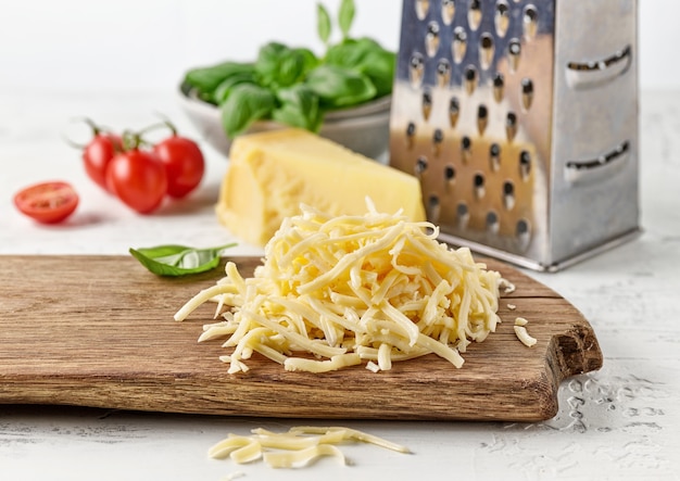 Grated cheese on wooden kitchen cutting board