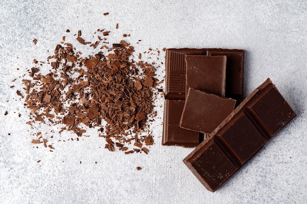 Grated chocolate and pieces of tasty chocolate on table