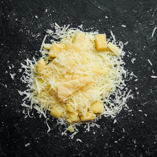 Foto parmigiano grattugiato formaggio vista dall'alto su uno sfondo di pietra nera