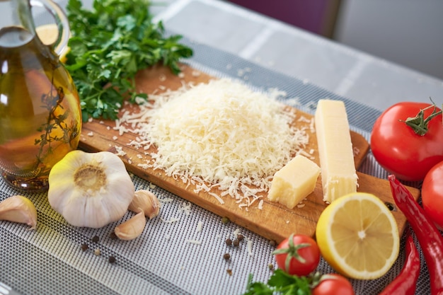 Grated parmesan cheese on a wooden cutting board at domestic kitchen