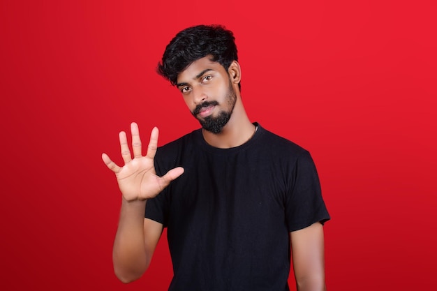 Foto gratis foto jonge man, gekleed in een zwart t-shirt met een opgeheven gebaar met vijf vingers