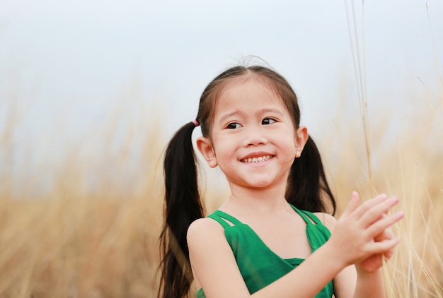 Gratis gelukkig kind meisje in gedroogd gras veld met glimlachen.