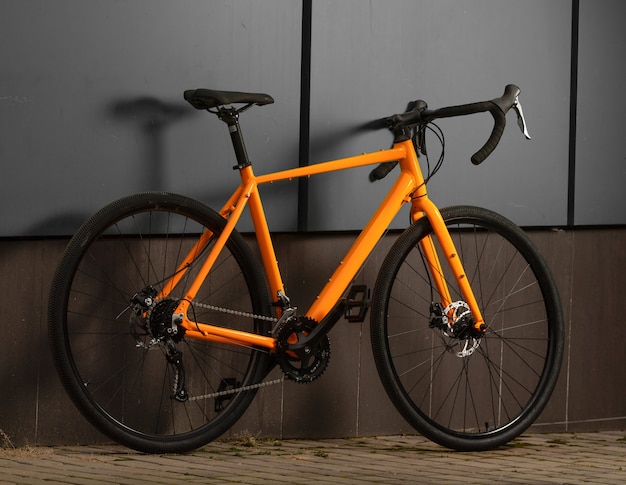 Фото Гравийный велосипед. оранжевый велосипед для езды на велосипеде по серой стене