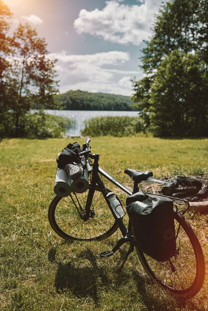 Photo a gravel bicycle with camping equipment for outdoor leisure activities summer adventures on the bike two travel mats on the front rack of the cycle