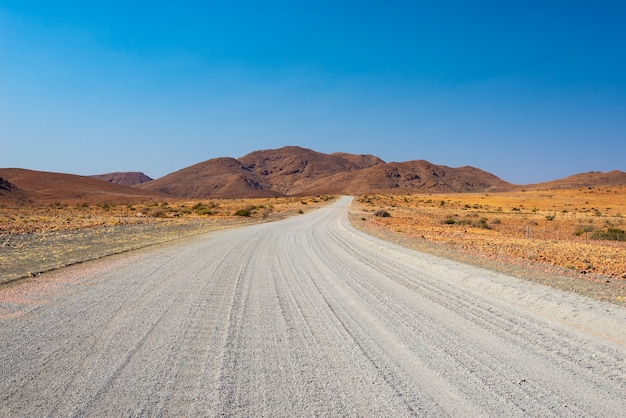 Damaraland Brandberg의 Twyfelfontein에서 다채로운 사막을 건너는 자갈 도로