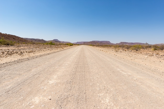 Strada di ghiaia che attraversa il deserto del namib, namibia, africa